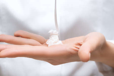 Female model hands with perfect manicure applying moisturizer cream. Female applying hands care...