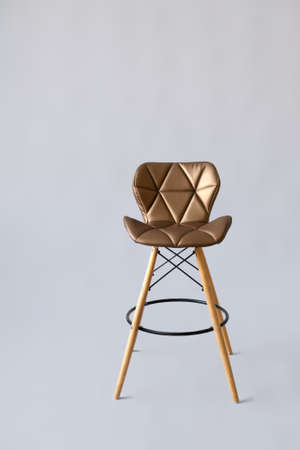 A modern golden bar seat on a gray background. Modern design golden cafe chair on a gray backgroundの写真素材