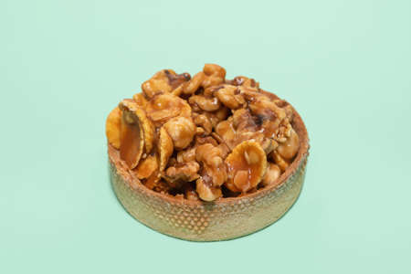 Tasty homemade nut turtle on blue background. Tart with nuts and caramel on a blue backgroundの写真素材