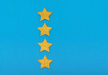 Four golden stars on blue background. Festive holiday pastel backdrop