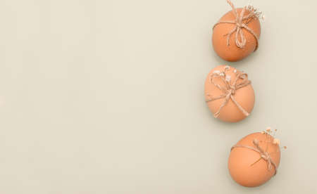Decorated Easter eggs with small white flowers on beige background. Decorated Christian Easter eggs on beige background with copy spaceの写真素材