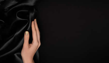 Female hand with golden nail design. Glitter gold nail polish manicure. Female model hand with...