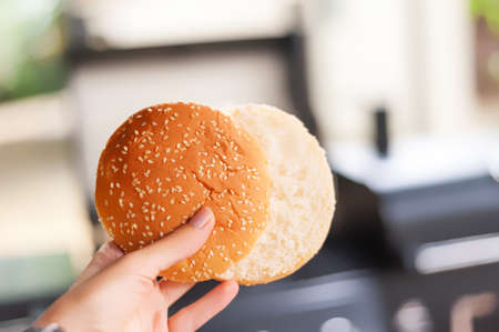 Close up of female hands holding delicious burger buns. White bread burger buns in female handの写真素材