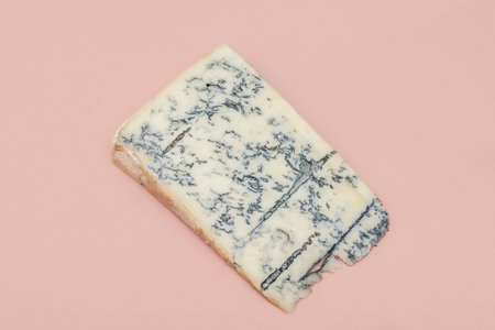 Italian traditional gorgonzola soft cheese with mold. Top Italian cheese - gorgonzola. Blue cheese family. Slice of blue italian cheese - gorgonzola, on pink background.の写真素材