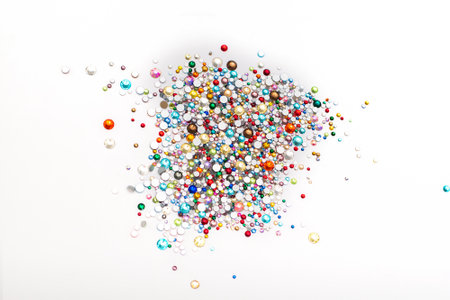 Colorful rhinestone background. Mix of Shiny rhinestones crystals texture as backdrop on white background. Glitter multi color gems on a white background.の写真素材