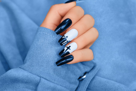 Halloween nail design with blue shade color with cross. Female hand with autumn manicure, top view. Halloween conceptの写真素材
