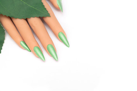 Female hand with long nails with glitter nail polish. Long green nail design. Woman hand with green manicure on white background.の写真素材