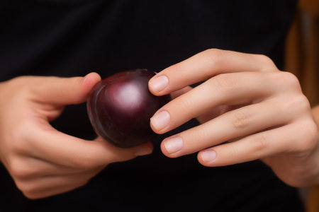 Female with ripe plum in hands close upの写真素材