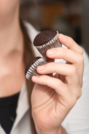 Hand Holding Chocolate Muffins. Presenting freshly baked chocolate muffinsの写真素材