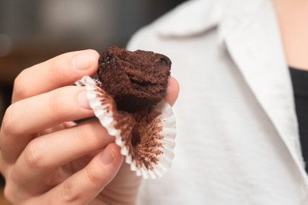 Hand Holding Chocolate Muffins. Presenting freshly baked chocolate muffinsの写真素材