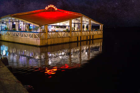 Wooden building of the greek tavern and seafood restaurant Flagman built in the water by night. Nessebar, Bulgariaのeditorial素材