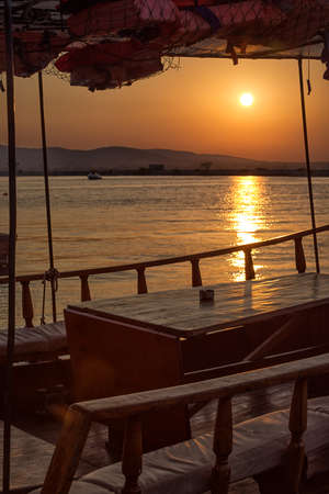 Motor boat deck with sunset view of the harbour.Boat on the pier in the calm water of the port of Sozopol, Bulgaria,Black Sea coastの写真素材