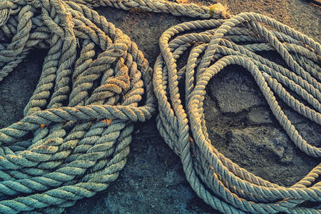 Pile of ship ropes. Ship ropes leying on the pier of a harbourの写真素材