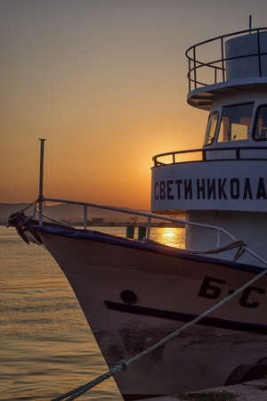 Passenger ship in the harbour on sunset.St.Nicolaus ship on the pier in the calm water of the port of Sozopol, Black Sea coastのeditorial素材