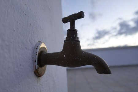 an old faucet with a rustic color and white backgroundの写真素材