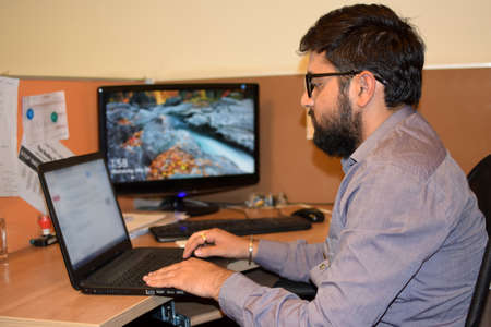Young employee working on laptop during office working hours in office