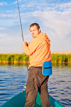Fisherman watching back cautious, like a poacher.の写真素材