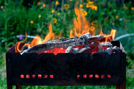 Burning wood in old black smoked brazierの写真素材