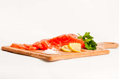 Salmon fish on board with salt and lemonの写真素材
