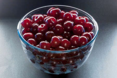 Glass bown with cherry berries on whiteの写真素材