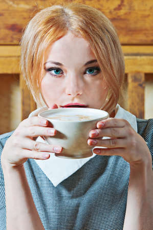 woman with cup of coffee in grey suitの写真素材
