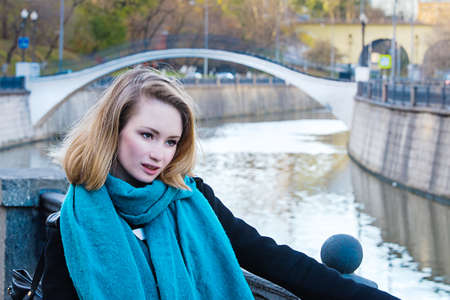 Blond Girl at embankment in Moscow with bridge in backgroundの写真素材