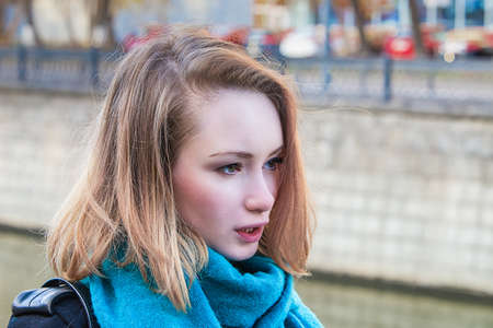 Blond Girl at embankment in Moscow with bridge in backgroundの写真素材