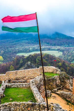 Hungarian flag under ancient ruined fortress Csesznekの写真素材