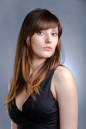 Young woman with long brown hairs in black dressの写真素材