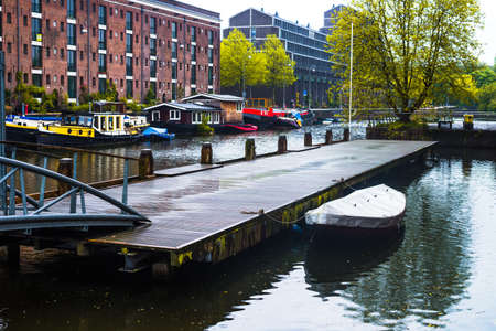 AMSTERDAM, NETHERLANDS - 11 May 2014. Pontoon boat dock along the Entrepotdok canal or waterway on 11 May in Amsterdam, Holland.のeditorial素材