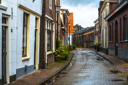 A cobbled street of old houses on a wet day at Muiden, Holland.のeditorial素材