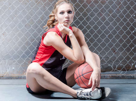 Woman on floor posing with the basket ballの写真素材
