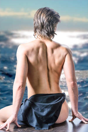Powerlifting woman back with muscle shaded relief with sea landscape backgroundの写真素材