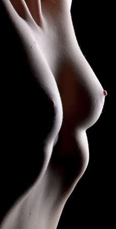 Female body with open breast on dark backgroundの写真素材