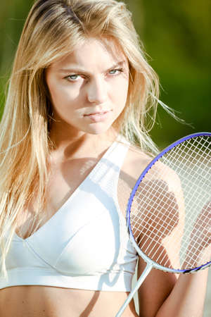 Badminton player. Blond pretty girl with a racket on a sand beachの写真素材