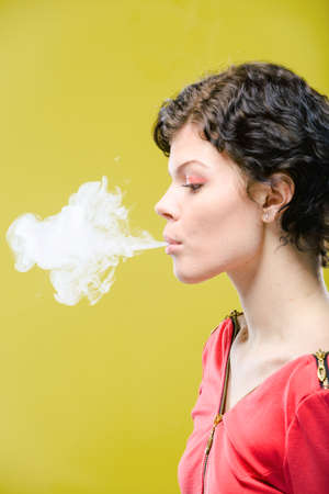 Smoking girl on colored background. Natural unretouched image.の写真素材