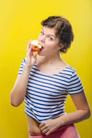 Girl with red apple on colored background. Natural unretouched image.