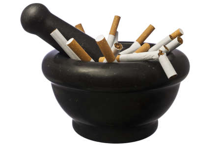 Quit smoking - Pestle and mortar with crushed cigarettes isolated over whiteの写真素材