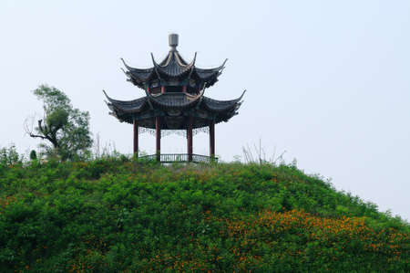 In full of flowers and grass on the hillside there is a beautiful pavilionの写真素材