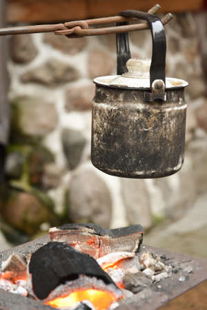 the kettle is suspended over the embers. Camping.の写真素材