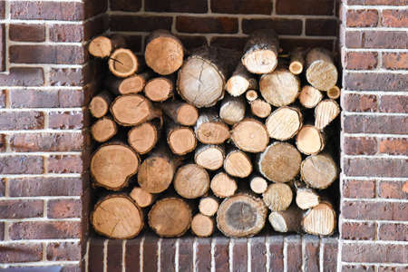 Stacked wooden logs in a niche. The wood in the fireplace. Fireplace room.