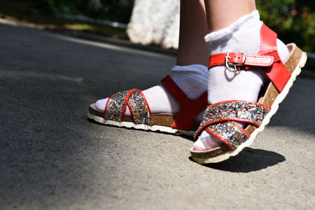 elegant shiny sandals on the legs of the girl. orthopedic sandals. legs close up.の写真素材
