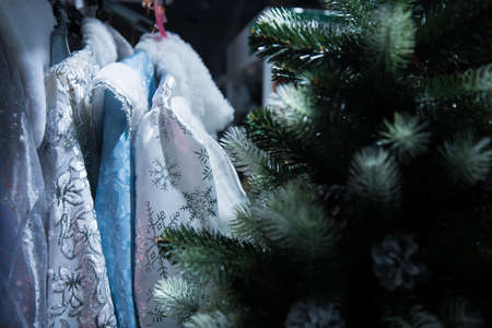 Clothes for Russian Christmas characters: Santa Claus and snow maiden. Clothes hang in a row on hangers, sold in the store. Christmas clothes.の写真素材