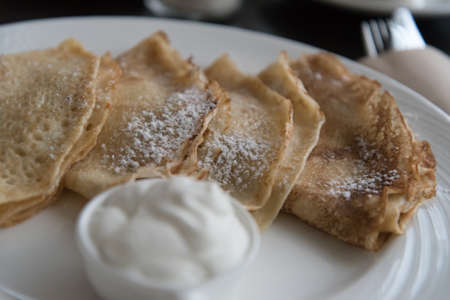 Pancakes with sour cream on a large white plate. Russian pancakes. Life style.の写真素材