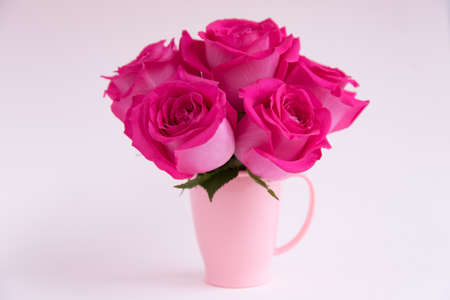 Bouquet of pink roses on a light background. A bouquet of flowers stands in a pink mug. Pink vase. Stylish bouquet.の写真素材