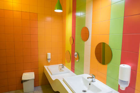 Toilet room, hand wash area. The bathroom is decorated in bright cheerful colors. Area for adults...