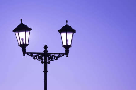 Urban landscape. Street lamp with a lamp in a classic style against a purple sky. Beautiful postcard.の写真素材