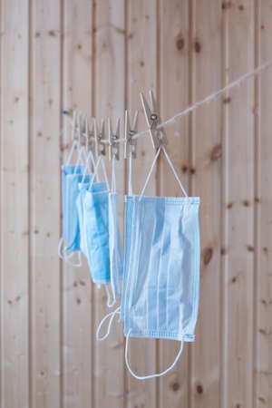 Disposable medical masks hang on a clothesline. Concept. Reuse. Deficit