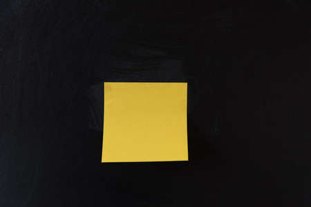 A sheet of yellow sticker pasted on a black background. reminder concept.の写真素材