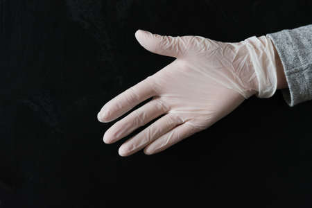 A hand in a white medical glove, extended to shake hands. Greeting, greeting, security and protection concept. pandemic.の写真素材